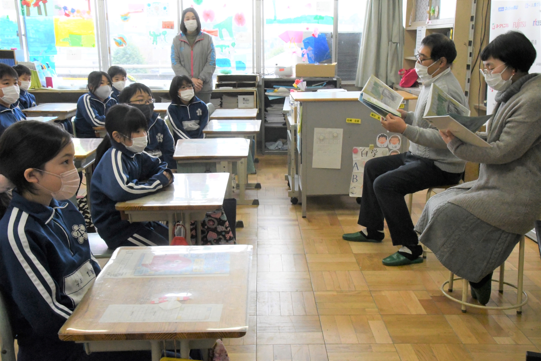 児童に読み聞かせをする（右から）よしもとさんと江藤さん